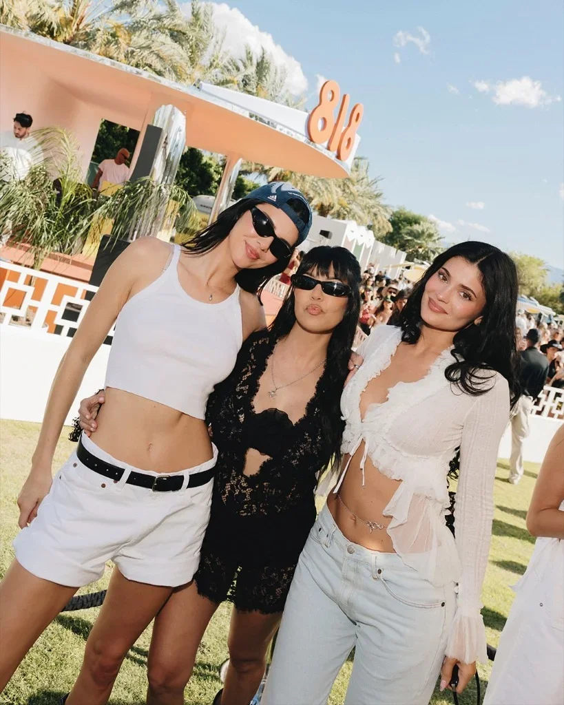 Kendall Jenner, Kourtney Kardashian, and Kylie Jenner posing outside the 818 Outpost pavilion during Coachella 2026