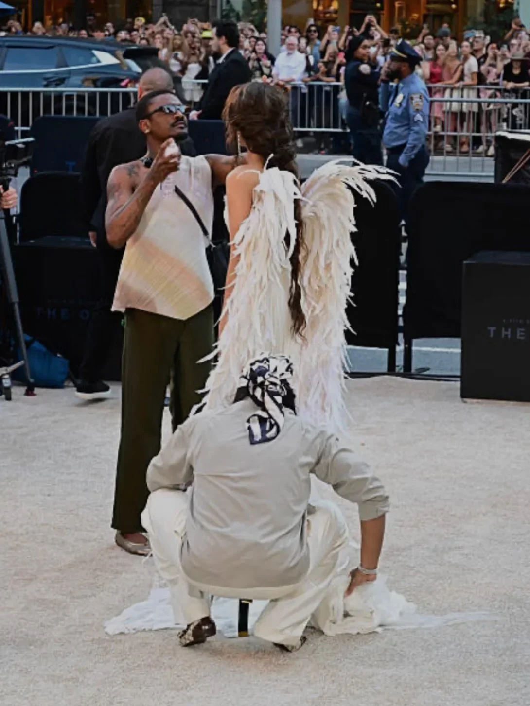 Law Roach and Coree Moreno adjusting Zendaya's Matières Fécales winged gown on the red carpet at The Odyssey New York premiere