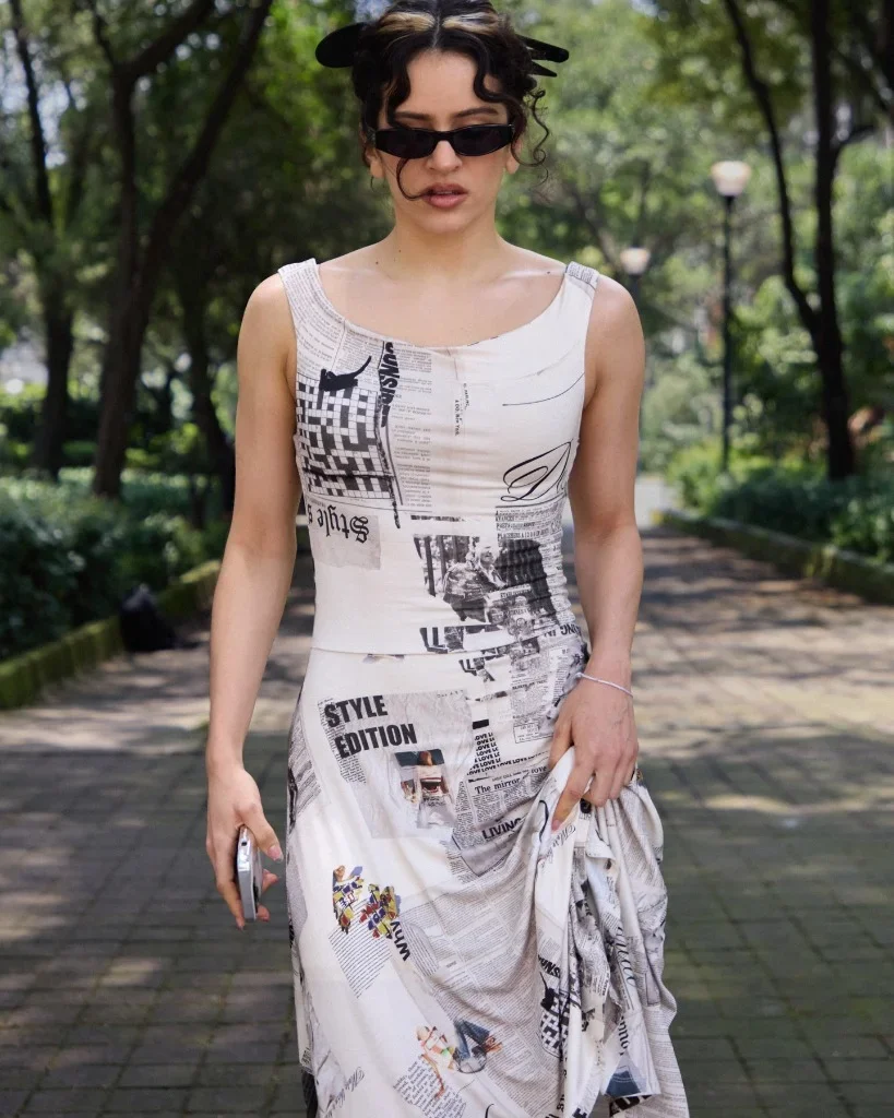 Rosalía styled with angular sunglasses and the archival Desigual newspaper print bodice