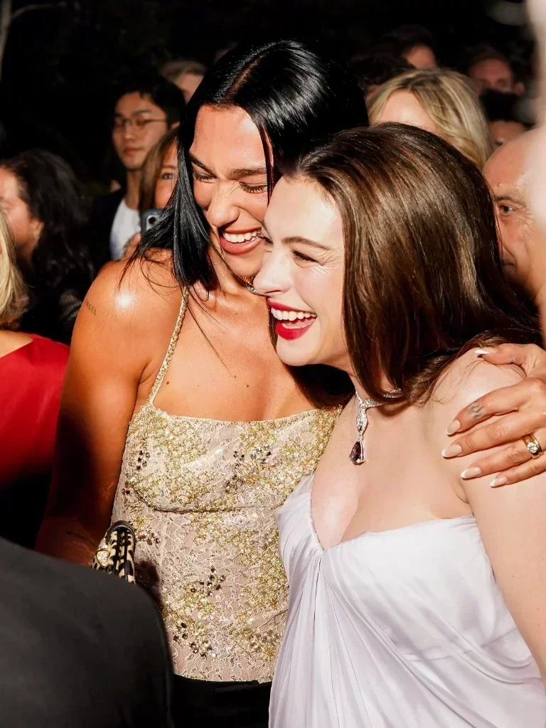 Anne Hathaway and Dua Lipa laughing together at the Bvlgari Serpenti Infinito launch