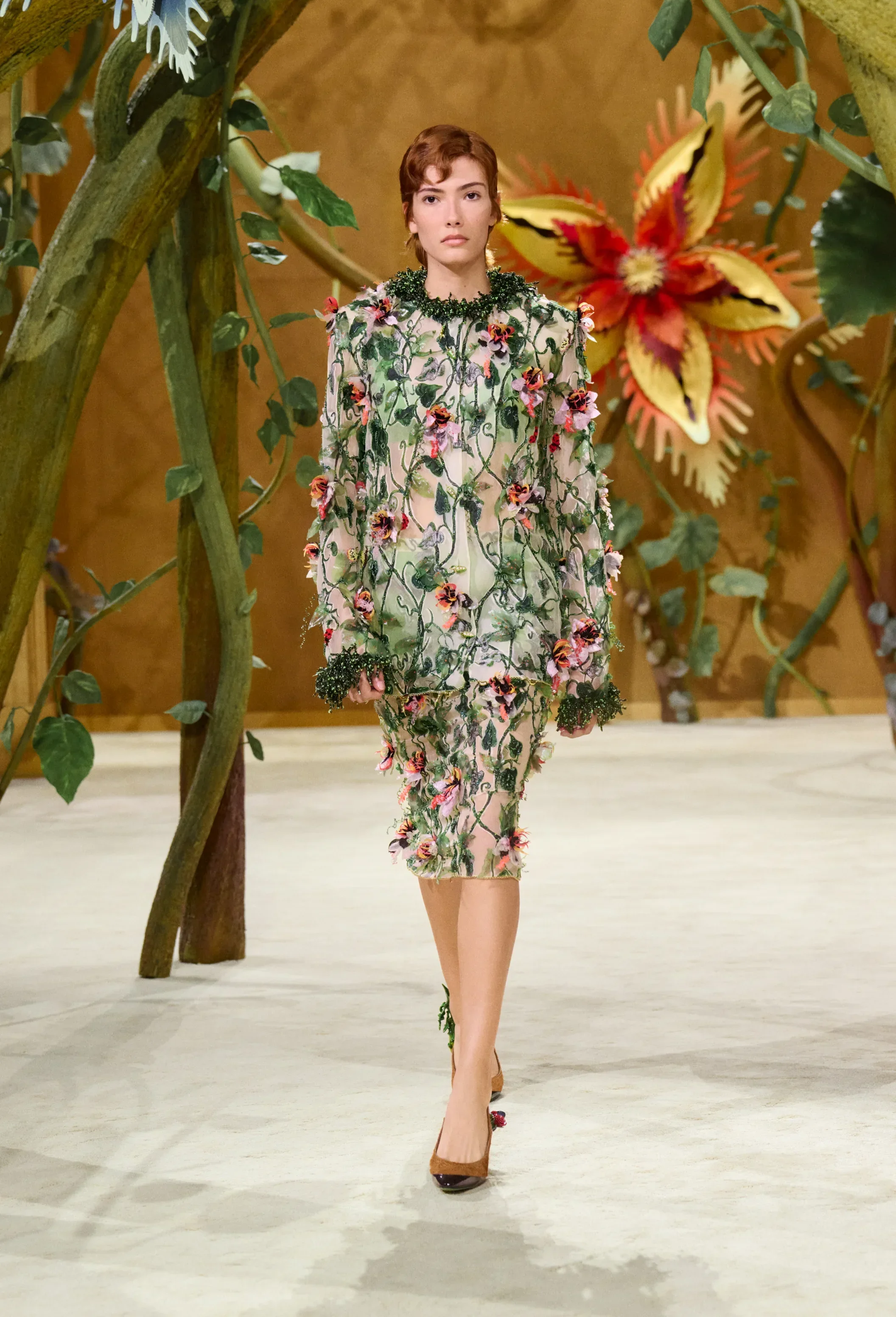Model wearing translucent ensemble with hand-embroidered climbing vines