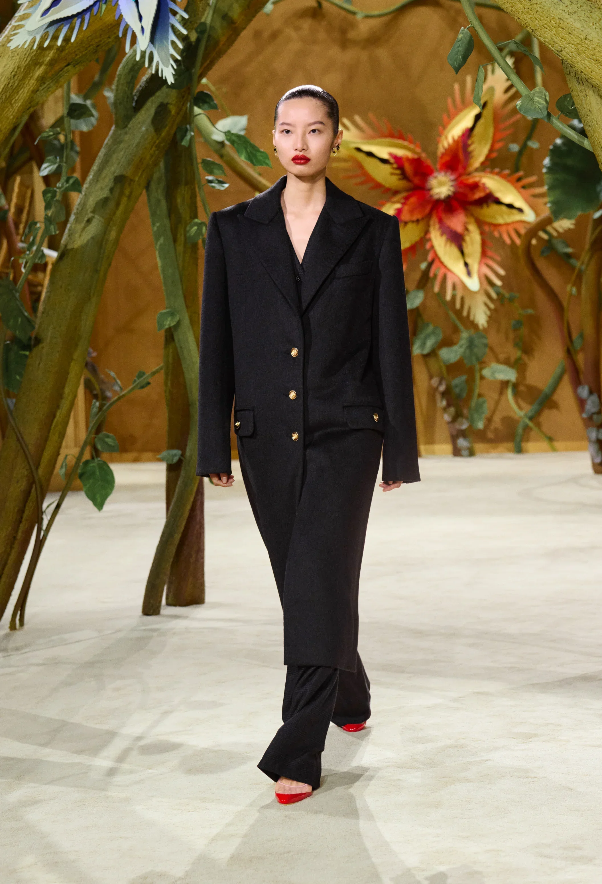Model wearing streamlined black tunic and tailored trousers