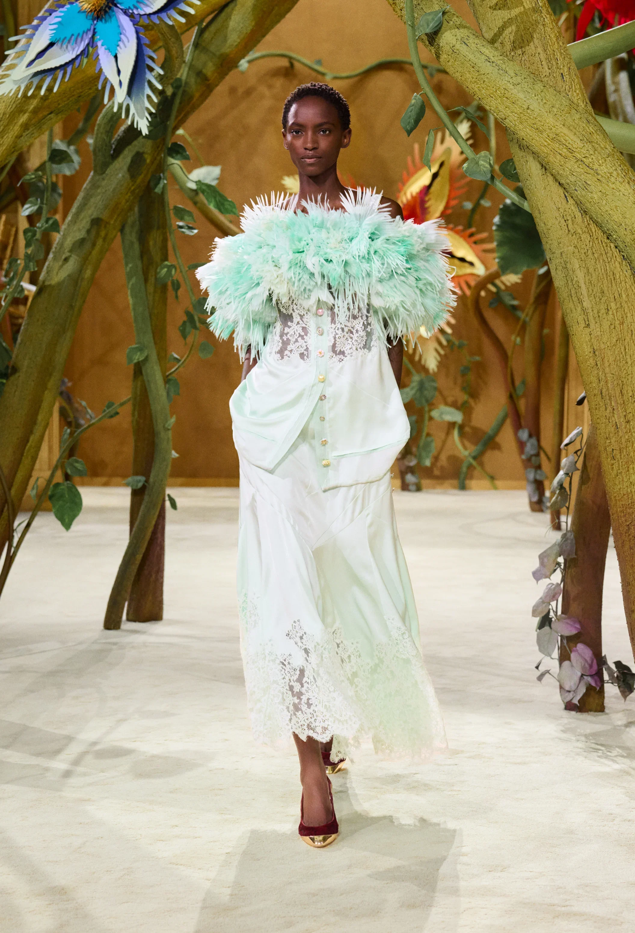 Model wearing mint feather-trimmed couture dress