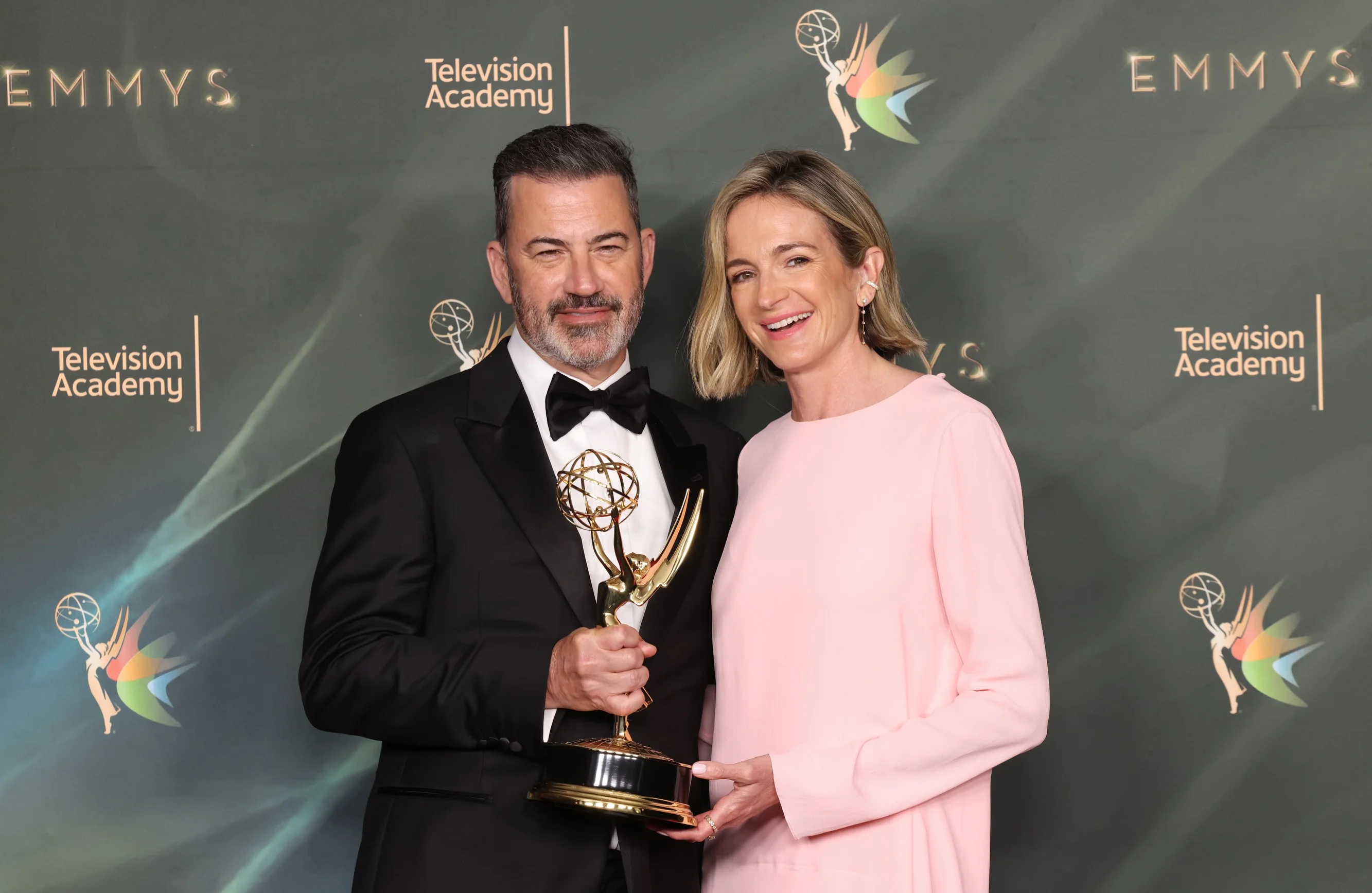 Two creative collaborators beaming in black tie with their twin Emmy statuettes
