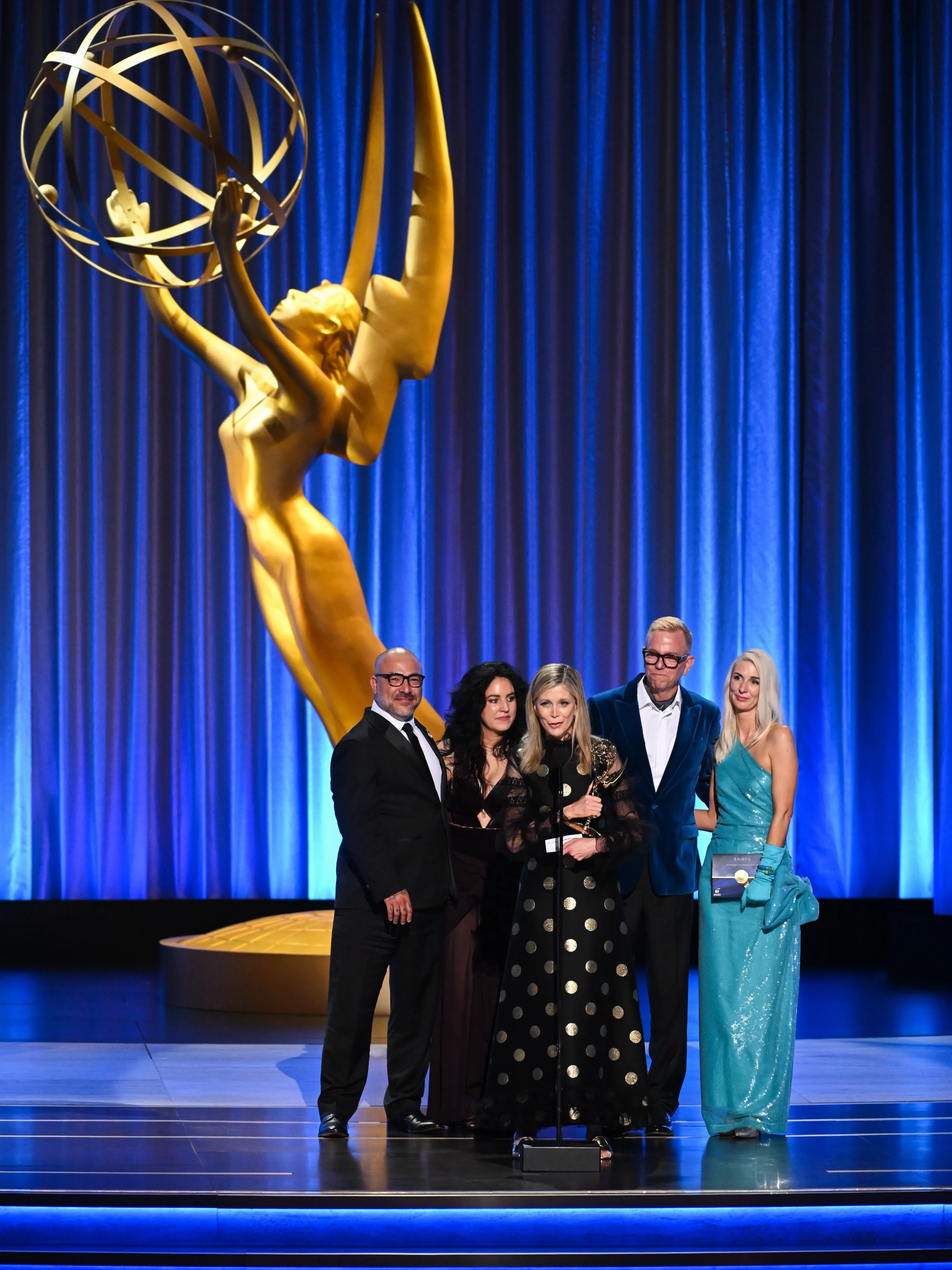 Mariska Hargitay in vibrant scarlet gown holding two Emmy statuettes