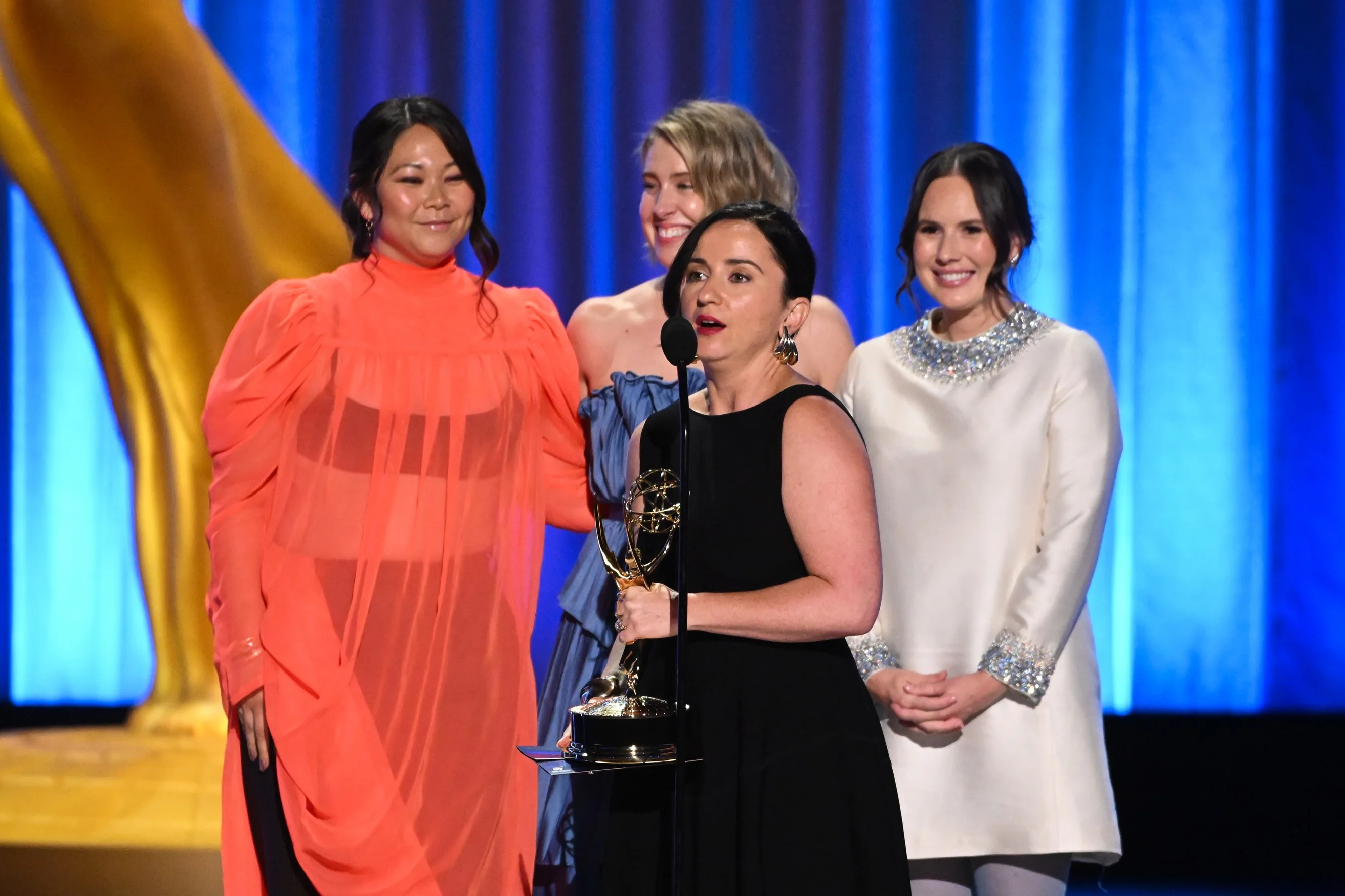 Creative production team celebrating their Emmy victory together on stage