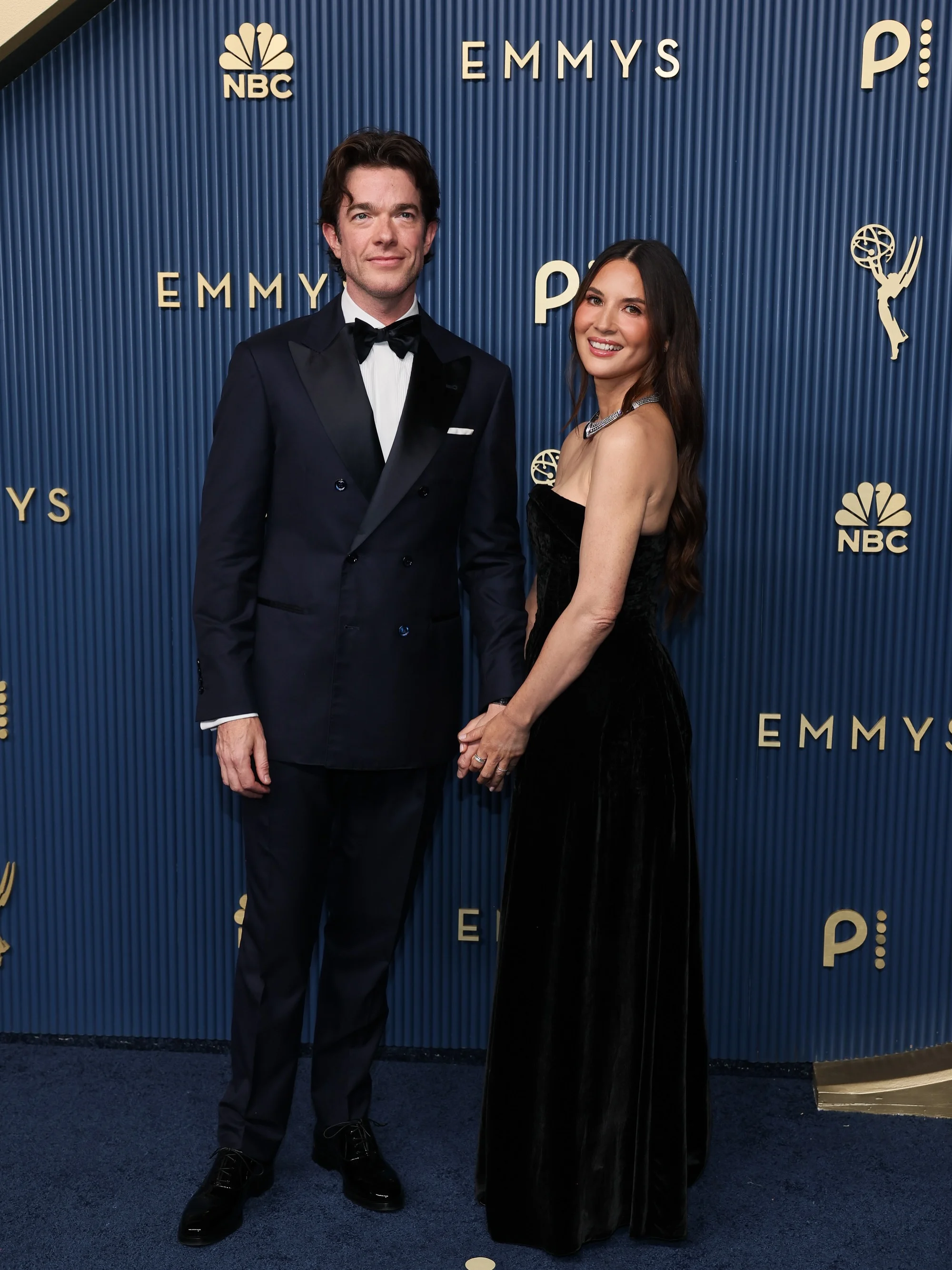 John Mulaney and Olivia Munn arriving hand-in-hand in coordinated eveningwear