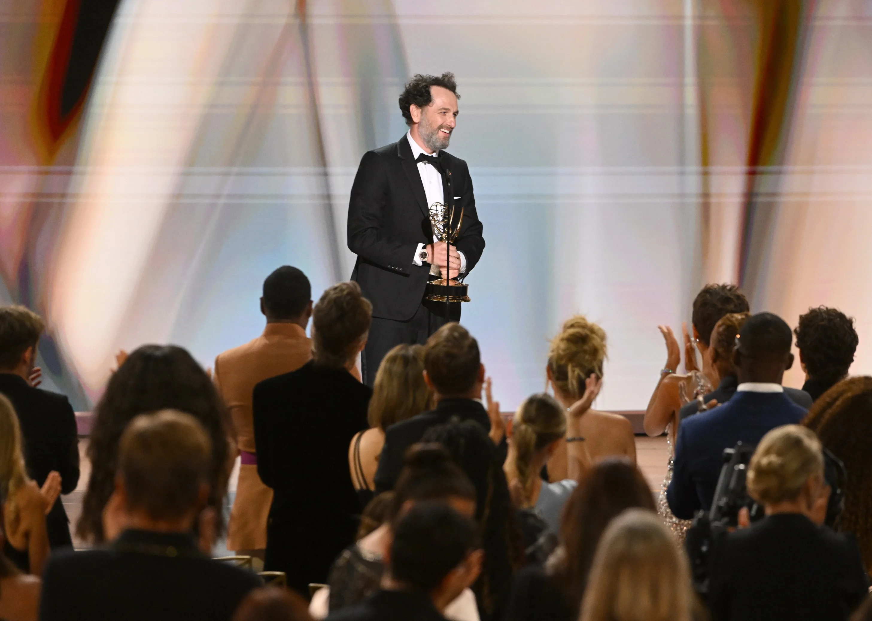 View from the ballroom audience of the winner delivering remarks on stage