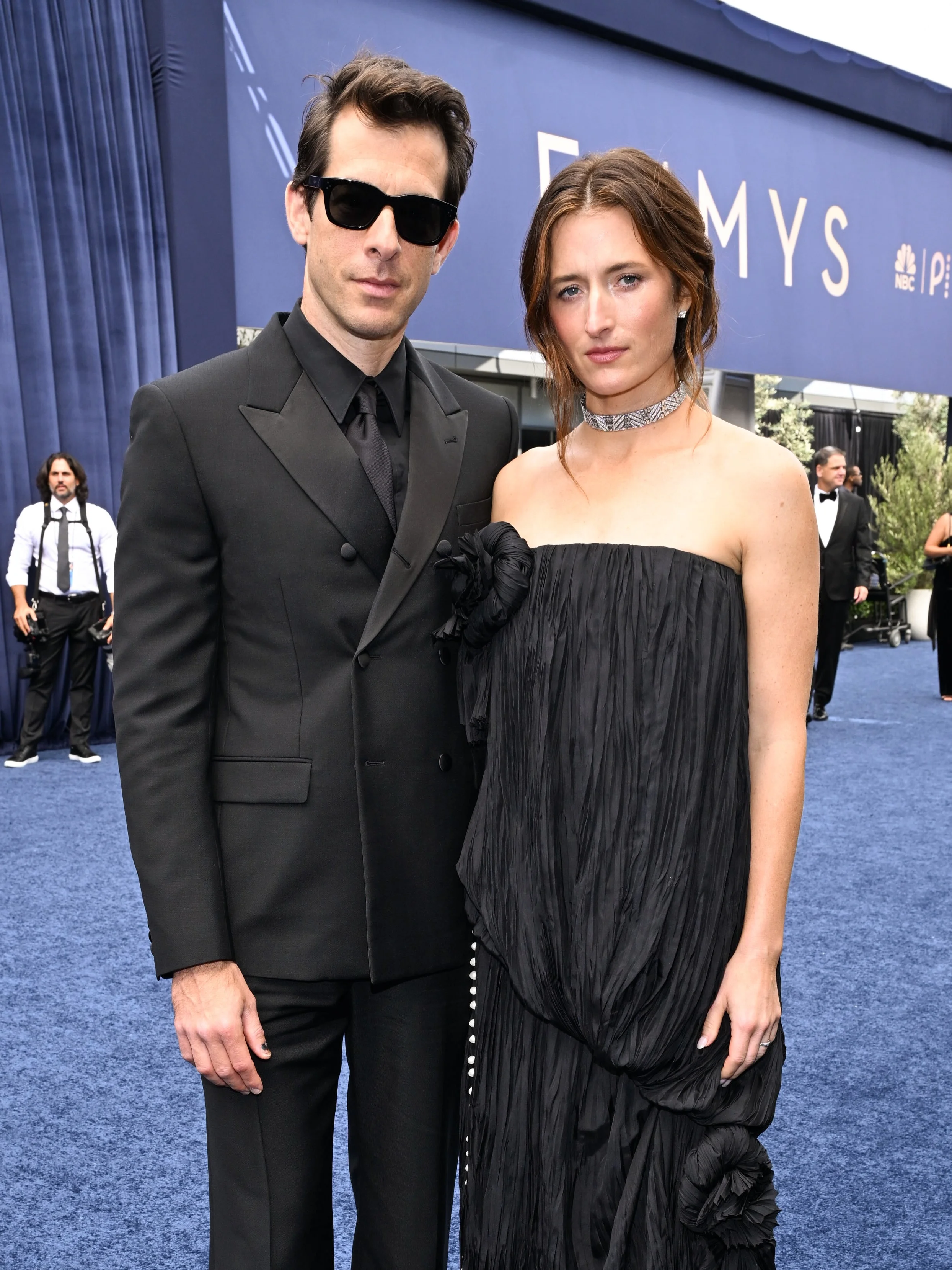 Couple in modern avant-garde black evening tailoring wearing dark sunglasses