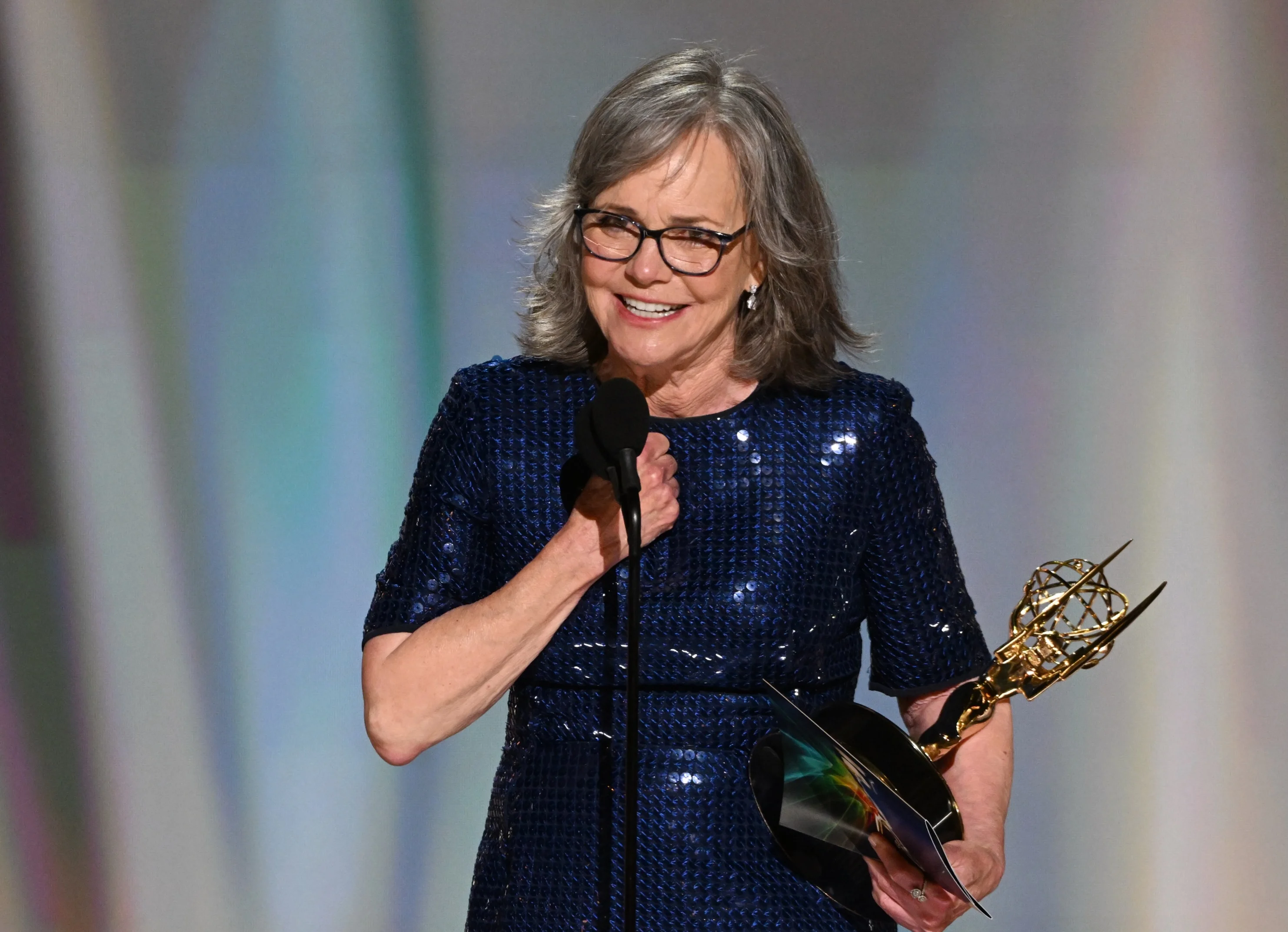 Sally Field holding Emmy statuette wearing midnight navy sequined gown